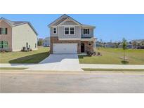 Two-story home with gray siding, brick accents, and a two-car garage at 247 Tulip Dr, Covington, GA 30016