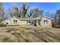 Attractive stone facade adorns this charming single story home with a spacious lawn at 1721 Hortense Nw Pl, Atlanta, GA 30318