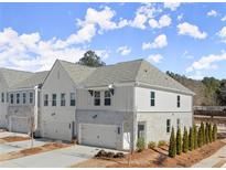 Two-story townhome with light gray siding, stone accents, and a two-car garage at 3576 Silvery Way, Powder Springs, GA 30127