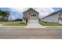 Two-story brick home with a two-car garage and landscaping at 257 Tulip Dr, Covington, GA 30016