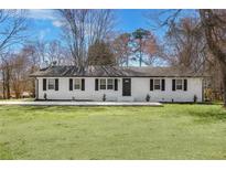 Charming one story home featuring black shutters, lush green lawn, and freshly painted brick exterior at 755 Tanner Rd, Dacula, GA 30019