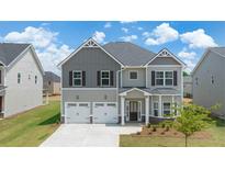 Two-story house with gray siding, two-car garage, and landscaping at 13490 Whitman Ln, Covington, GA 30014