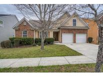 Brick house with two-car garage and landscaped lawn at 1077 Balvaird Dr, Lawrenceville, GA 30045