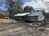 Ranch home with gray siding, red shutters, and a snow-covered roof at 3295 Highway 138 Ne, Conyers, GA 30013