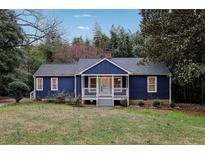 Charming blue home featuring a cozy front porch and mature landscaping at 1624 Venetian Sw Dr, Atlanta, GA 30311