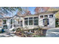 Stunning white brick home with black windows, landscaping, and a fountain at 2305 Sherbrooke Ne Dr, Atlanta, GA 30345