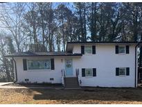 Charming two-story home featuring a white brick facade and a welcoming light blue front door at 2653 Williamsburg Dr, Decatur, GA 30034