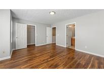 Spacious bedroom features wood-look flooring, a ceiling light, and an ensuite bathroom at 5615 Strathmoor Manor Cir, Lithonia, GA 30058