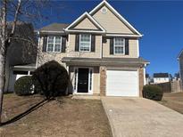 Two-story house with a beige exterior, black shutters, and a white garage door at 6403 Walnut Way, Union City, GA 30291