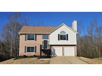 Two-story house with brick and vinyl siding, two-car garage, and a landscaped yard at 256 Kings Cv, Locust Grove, GA 30248