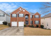 Brick two-story house with a two-car garage and landscaped yard at 7606 Forest Glen Way, Lithia Springs, GA 30122