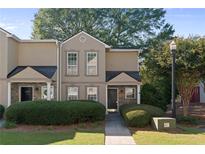 Tan two-story townhome with stone accents, landscaping, and a walkway at 1004 Masons Creek Cir # 1004, Atlanta, GA 30350