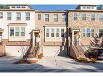 Brick front three-story townhome with attached two-car garage at 372 Provenance Dr, Sandy Springs, GA 30328