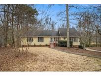 Charming single-story home with yellow siding, mature trees, and inviting front entrance at 4741 W Lake Se Dr, Conyers, GA 30094