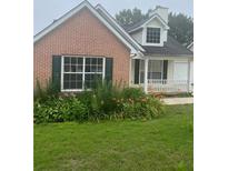 Charming brick home with a well-maintained lawn and colorful flowerbeds at 3745 Hudson Ct, Rex, GA 30273