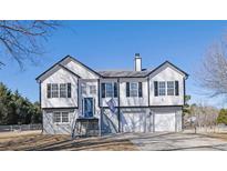 Two-story house with gray siding, a blue door and a two-car garage at 3601 Brookview Dr, Loganville, GA 30052