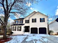 Two-story house with white brick exterior, black accents, and a two-car garage at 6467 Battery Pt, Stone Mountain, GA 30087