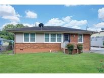 Brick ranch house with a well-maintained lawn and a satellite dish at 1083 Grace Dr, Forest Park, GA 30297