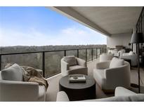 Expansive covered outdoor balcony featuring plush seating with a great view overlooking a forest landscape at 2520 Peachtree Nw Rd # 1202, Atlanta, GA 30305