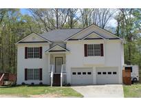 Charming two-story home with a well-manicured lawn, two car garage and a quaint front porch at 93 Highway 81, Oxford, GA 30054