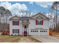 Two-story house with white siding, red shutters, and a two-car garage at 93 Highway 81, Oxford, GA 30054