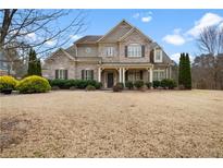 Charming two-story brick home with a well-manicured lawn and inviting front porch at 4535 Meadow Green Ln, Acworth, GA 30101