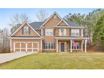 Charming two-story home with a two-car garage and well-manicured front lawn at 8270 Mossybrook Ln, Douglasville, GA 30135