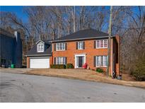 Charming brick two-story home with a well-manicured front yard and attached two-car garage at 6432 Phillips Pl, Lithonia, GA 30058