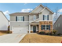 Two-story house with gray siding, stone accents, and a two-car garage at 251 Ivy Chase Loop, Dallas, GA 30157