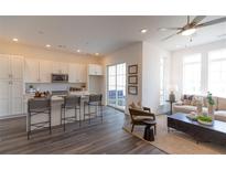 Open concept kitchen with island and stainless steel appliances flows into living room with ample natural light at 534 Sawnee Village Blvd # D65, Cumming, GA 30040