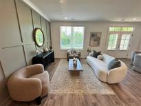 Bright living room features a curved sofa, modern decor, and neutral color palette, creating an inviting atmosphere at 534 Sawnee Village Blvd # D65, Cumming, GA 30040