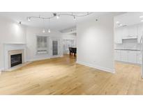 Light-filled living room with hardwood floors and fireplace at 211 Colonial Homes Nw Dr # 1105, Atlanta, GA 30309