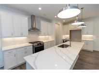 Modern kitchen with white cabinets, quartz countertops, and stainless steel appliances at 536 Sawnee Village Blvd # D66, Cumming, GA 30040