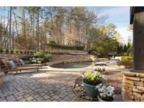 Inviting backyard oasis with a relaxing pool and stone patio at 6229 Grand Loop Rd, Sugar Hill, GA 30518