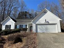 Charming single-story home with white siding, black shutters, and an attached two car garage at 1685 Keylake Dr, Suwanee, GA 30024