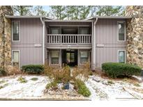 Gray condo building with wood railings and snowy landscaping at 4037 Woodridge Way, Tucker, GA 30084
