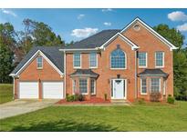 Brick two-story house with a two-car garage and landscaped lawn at 93 Carriage Lake Dr, Stockbridge, GA 30281