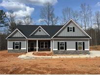 Charming single-story home featuring stone accents, gray siding, a covered porch, and black shutters against a blue sky backdrop at 459 Benson Meadows Dr, Dallas, GA 30157