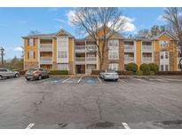 View of the apartment building exterior showing balconies, parking, and stone accents at 533 Bentley Pl, Tucker, GA 30084