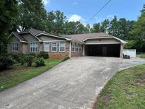 Brick ranch home with carport and landscaped yard at 6494 Pleasant Dr, Winston, GA 30187