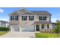 Two-story house with gray stone and white accents, two-car garage, and landscaped lawn at 3238 Champions Way, Loganville, GA 30052