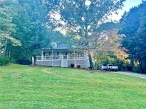 House exterior featuring a wraparound porch and landscaped yard at 414 Deering Dr, Douglasville, GA 30134