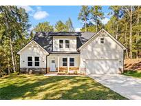 Craftsman style home with light beige siding, stone accents, and a two-car garage at 485 N Oakland Cir, Mcdonough, GA 30253