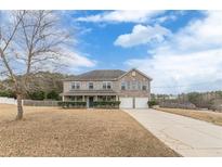 Brick house with a two-car garage and manicured lawn at 601 Rangeley Meadows Ct, Hampton, GA 30228