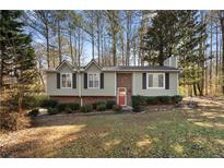 Brick ranch house with a red door and a well-manicured lawn at 3335 Pinta Way, Douglasville, GA 30135