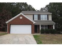 Brick and vinyl two-story house with attached garage and landscaping at 215 Brookwood Cv, Atlanta, GA 30349