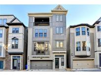 Three-story townhome with gray exterior, two-car garage, and balcony at 606 Broadview Ne Ter, Atlanta, GA 30324