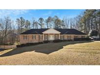 Brick ranch home with a large yard and mature trees at 157 Timberlost Trl, Suwanee, GA 30024