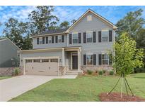 Two-story home with gray siding, stone accents, and a two-car garage at 1600 Fuma Leaf Way, Mcdonough, GA 30253