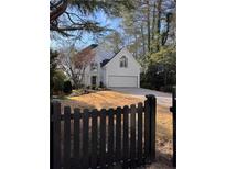 Charming two-story white home with a spacious driveway and inviting curb appeal enhanced by black fence and a basketball court at 4086 Haverhill Dr, Atlanta, GA 30342